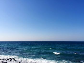 Scenic view of sea against clear blue sky