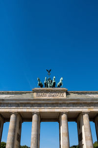 Low angle view of statue against blue sky