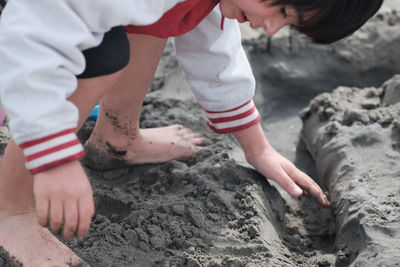 Carefree boy playing with sand at beach