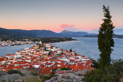 High angle view of townscape by sea against sky during sunset