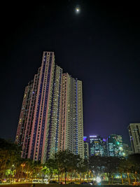 Low angle view of illuminated buildings against sky at night