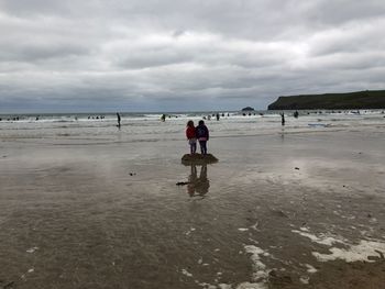 People on beach against sky