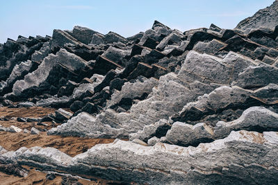 Low angle view of rocks on mountain against sky