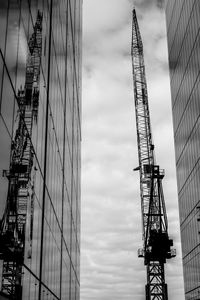 Low angle view of cranes against sky