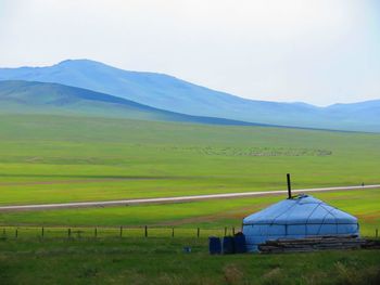 Scenic view of grassy field against sky