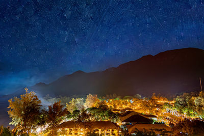 Illuminated buildings in city against sky at night