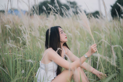 Side view of young woman lying on field