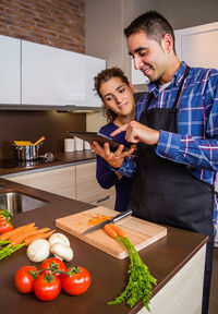Happy man and woman standing in kitchen at home