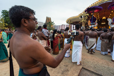 Rear view of people at temple against sky in city