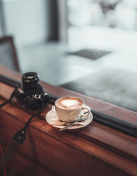 High angle view of coffee cup and camera