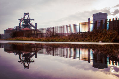 Reflection of building on lake against sky