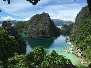 Scenic view of sea by mountains against sky