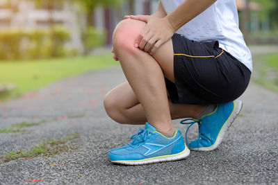 Low section of woman suffering from pain on road