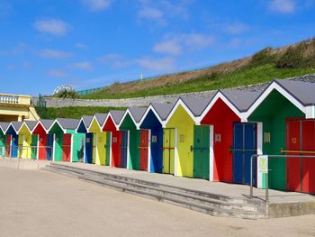 Multi colored umbrellas on beach against blue sky