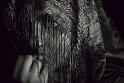 Young woman with hands hair against black background