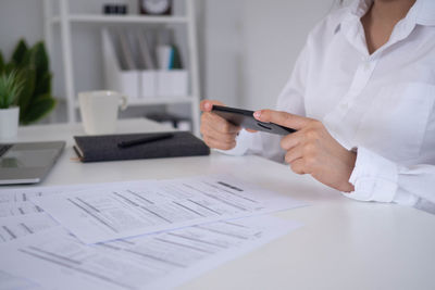 Midsection of woman using laptop on table