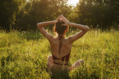 Woman with arms raised on field