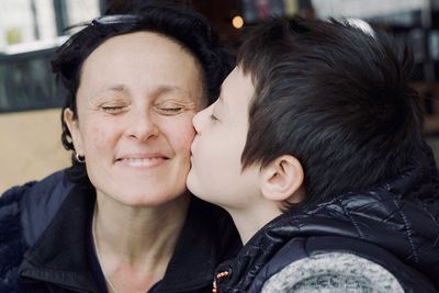 Boy kissing smiling mother