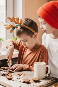 Boys decorate christmas cookies with white icing. children decorate a gingerbread man