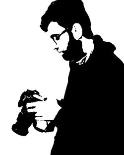 Low angle view of silhouette man holding camera over white background