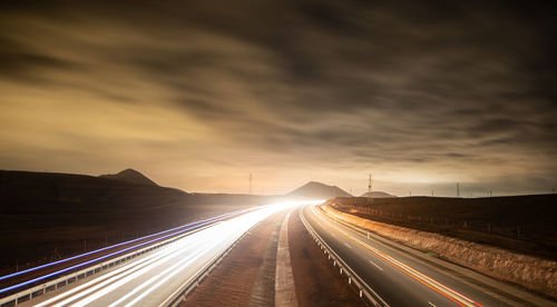 Light trails on highway at sunset