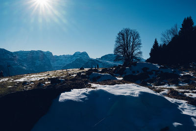 Scenic view of snowcapped mountains against blue sky