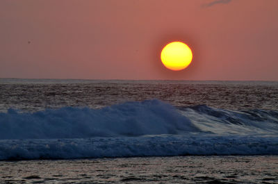 Scenic view of sea against orange sky