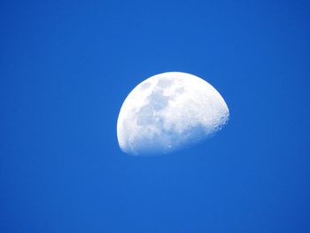 Low angle view of moon against blue sky