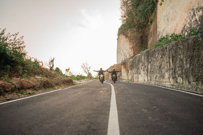 Rear view of man walking on road