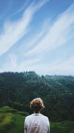 Rear view of woman on landscape against sky