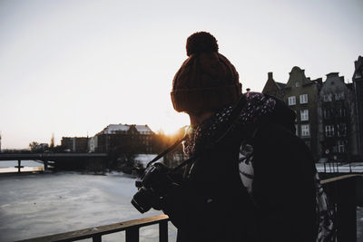 Man using camera while standing in city during winter