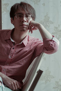 Portrait of young man sitting on sofa at home