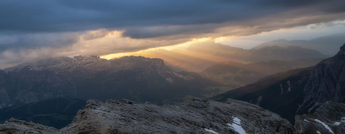 Scenic view of mountains against cloudy sky during sunset