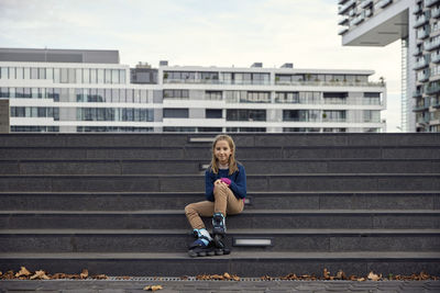 Portrait of woman sitting on staircase in city