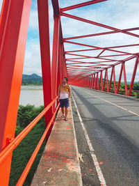 Rear view of man walking on bridge