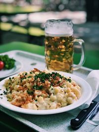 Close-up of pasta served with beer on table