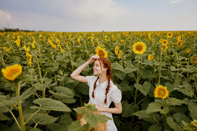 Woman standing amidst yellow flowers