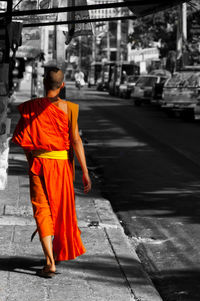Rear view of people walking on cross