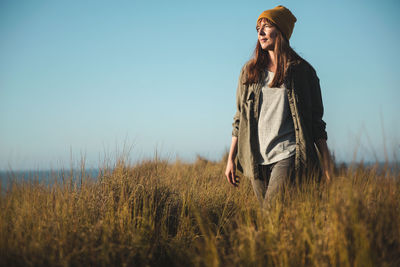 Woman standing on field against sky