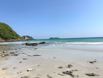 Scenic view of beach against clear blue sky