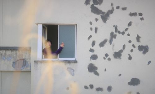 Reflection of woman in window on wall