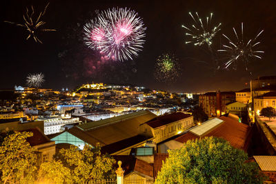 Firework display over cityscape at night