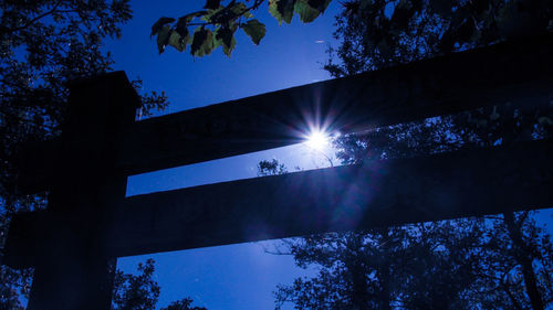 Low angle view of illuminated trees against blue sky