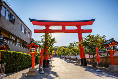 Red flags on footpath by building against sky