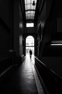 Rear view of silhouette man walking in corridor of building