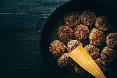 Spatula with meatballs in cooking pan