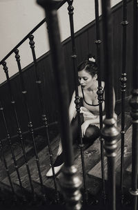High angle view of young woman sitting on steps at home