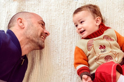 Smiling father lying with daughter at home