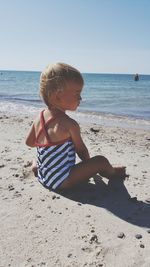 Boy on beach against clear sky