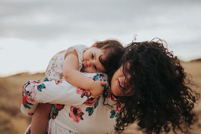 Woman with mother and daughter against sky